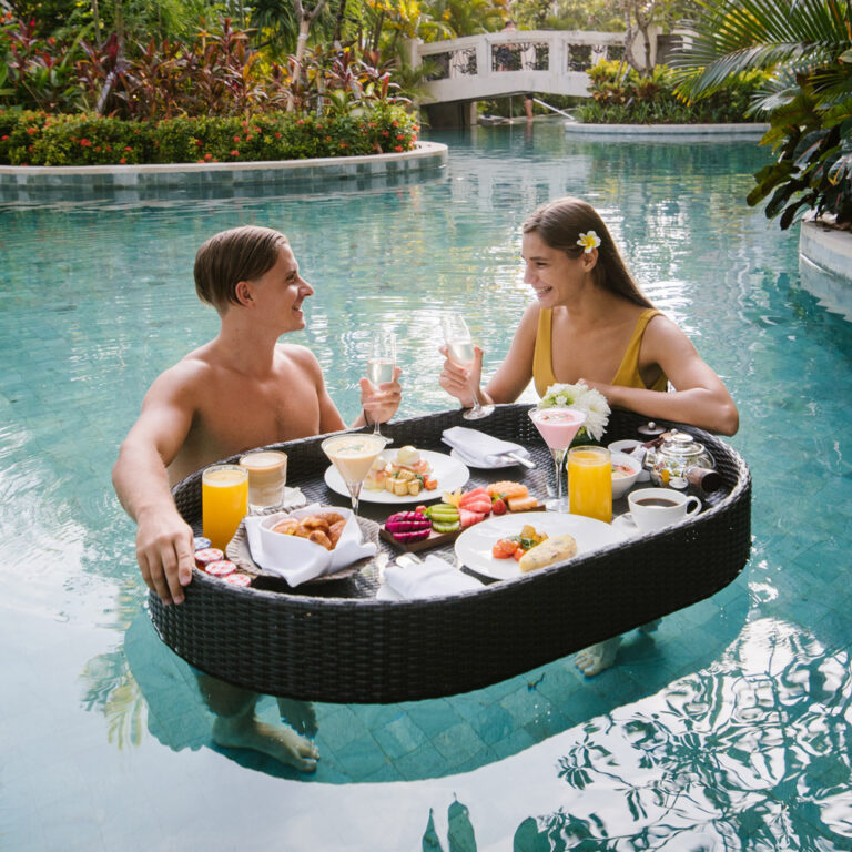 Couple enjoying a floating breakfast in the resort pool at Sofitel Bali Nusa Dua
